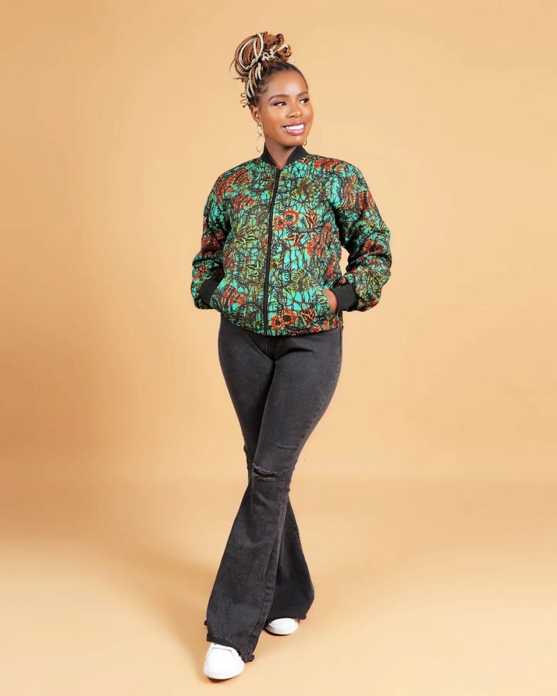 An African woman wearing an Ankara bomber jacket styled with casual streetwear.