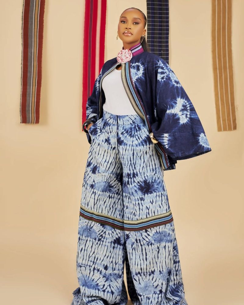 The woman is dressed in a minimalist Kampala Adire outfit, adorned with subtle patterns.