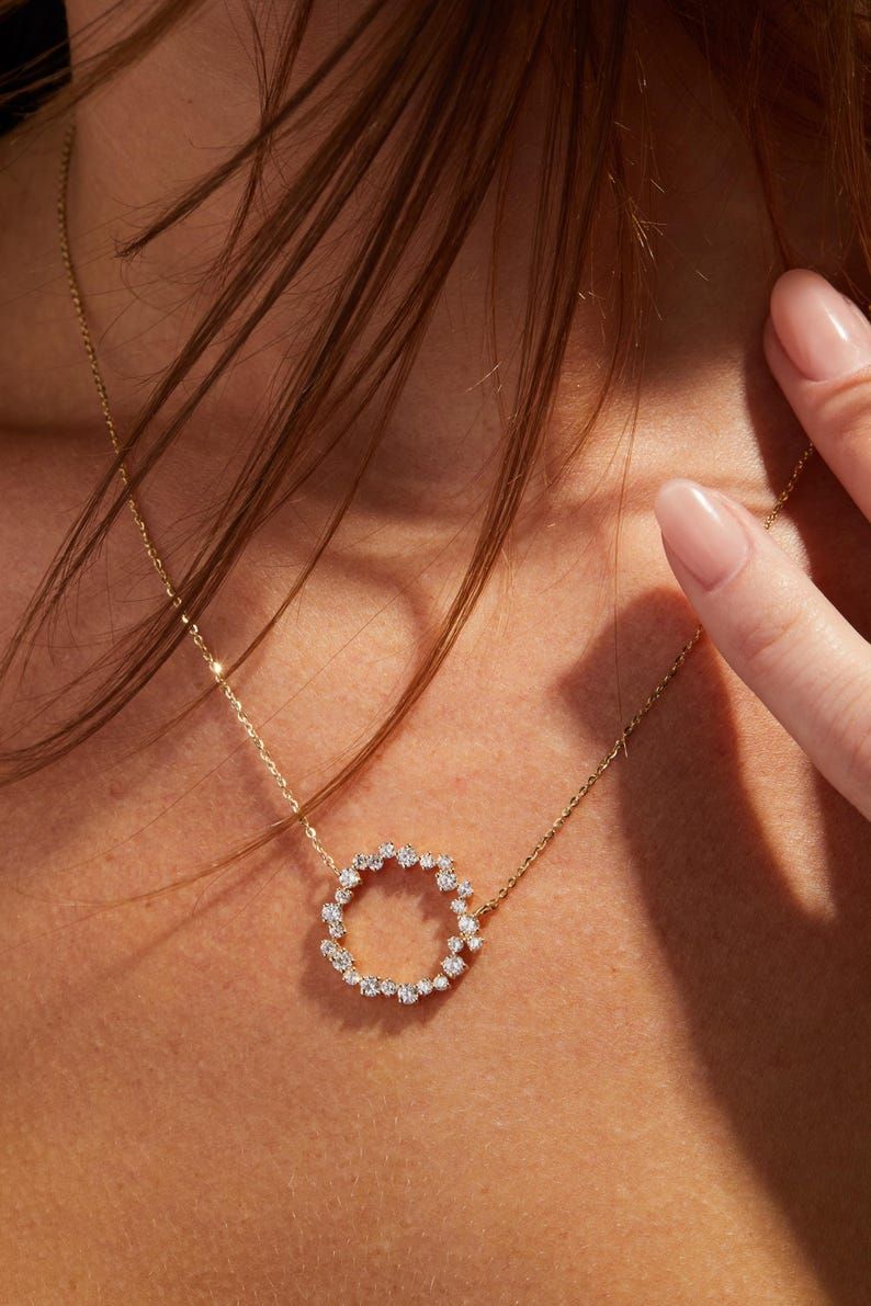 A woman wearing a sustainable lab-grown diamond pendant.
