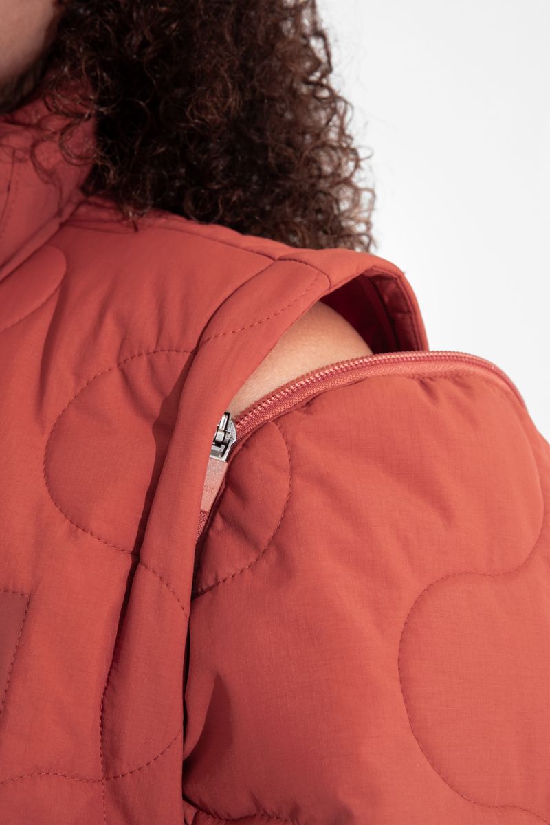 Close-up of a structural modular jacket showing detachable components and innovative closures, illustrating functionality as a luxury design feature.
