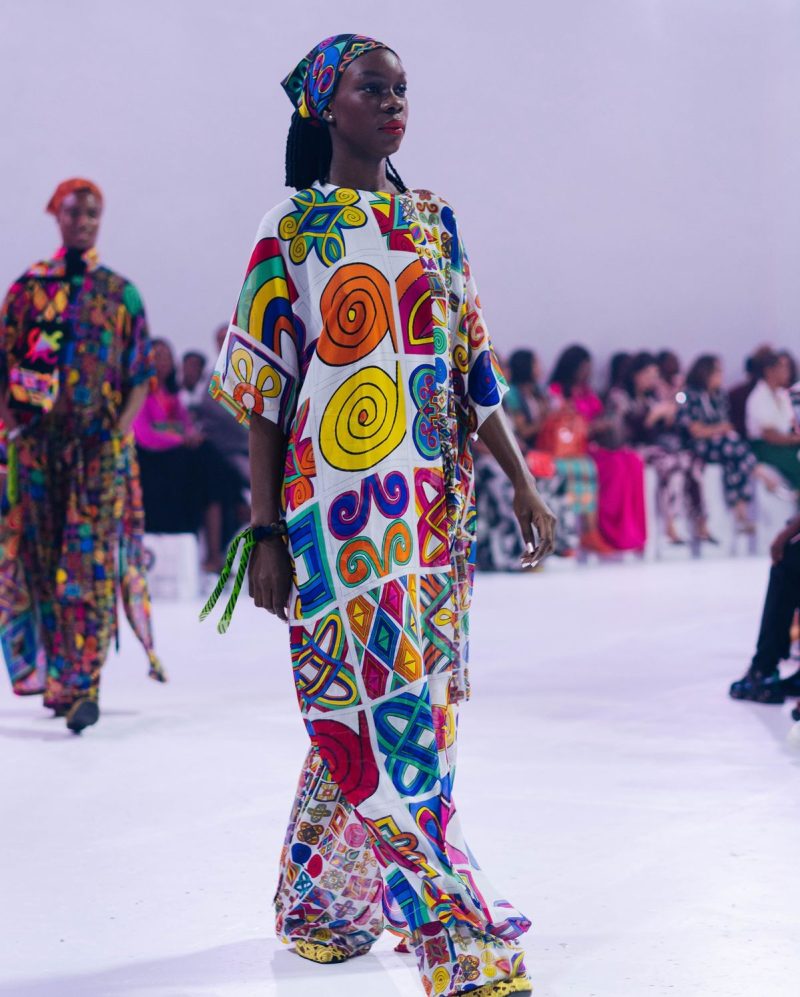 A model walking in African-inspired wear on a fashion runway.