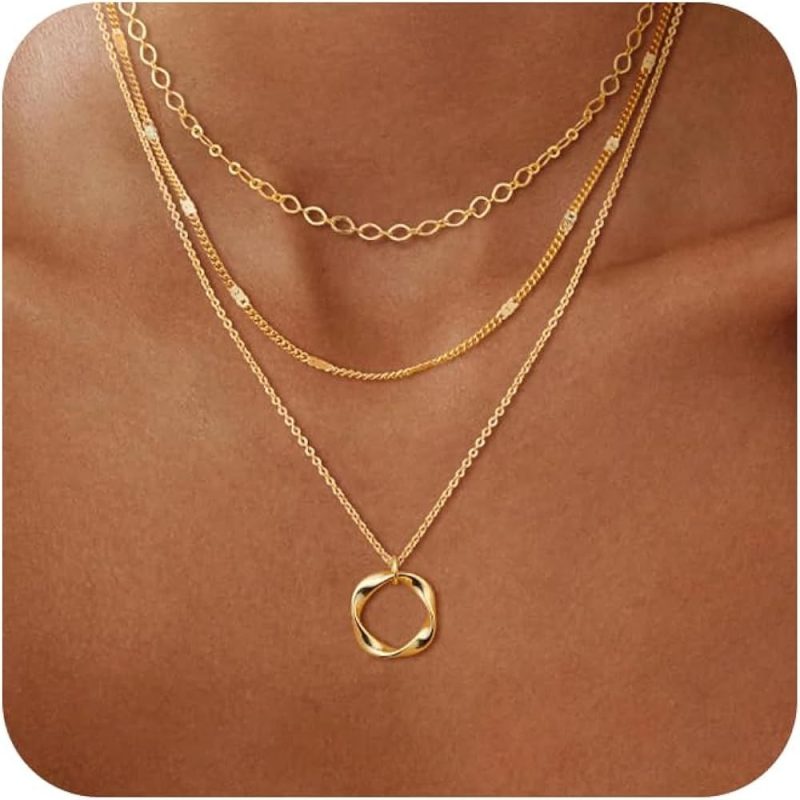 Minimal gold jewellery assortment, including hoops and layered necklaces.