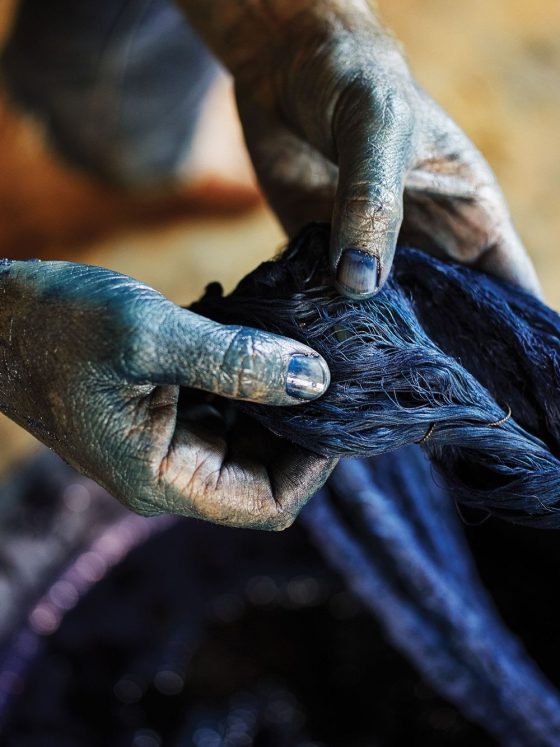 Close-up shot of an African textile dyer with naturally stained hands, symbolising generational expertise and artisanal pride