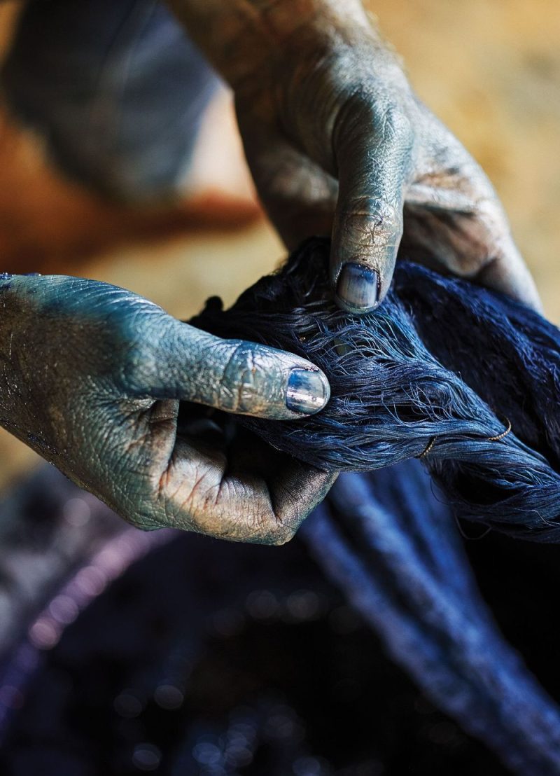Close-up shot of an African textile dyer with naturally stained hands, symbolising generational expertise and artisanal pride
