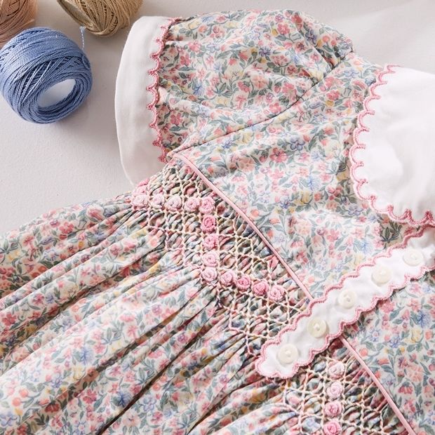 Close-up of fine, hand-finished stitching on a children's garment, illustrating the heirloom quality and meticulous craftsmanship of Black Children's Luxury Fashion Brands.