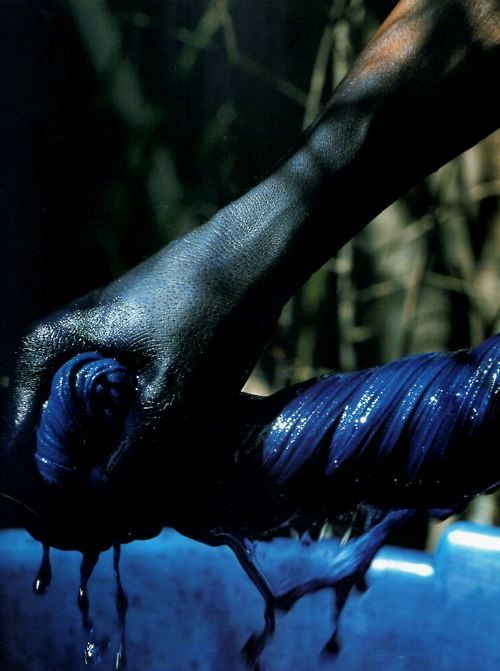 An artisan demonstrates the traditional, low-toxicity indigo dyeing process, showcasing the complex labour behind African textile production, which is the key to authentic luxury.