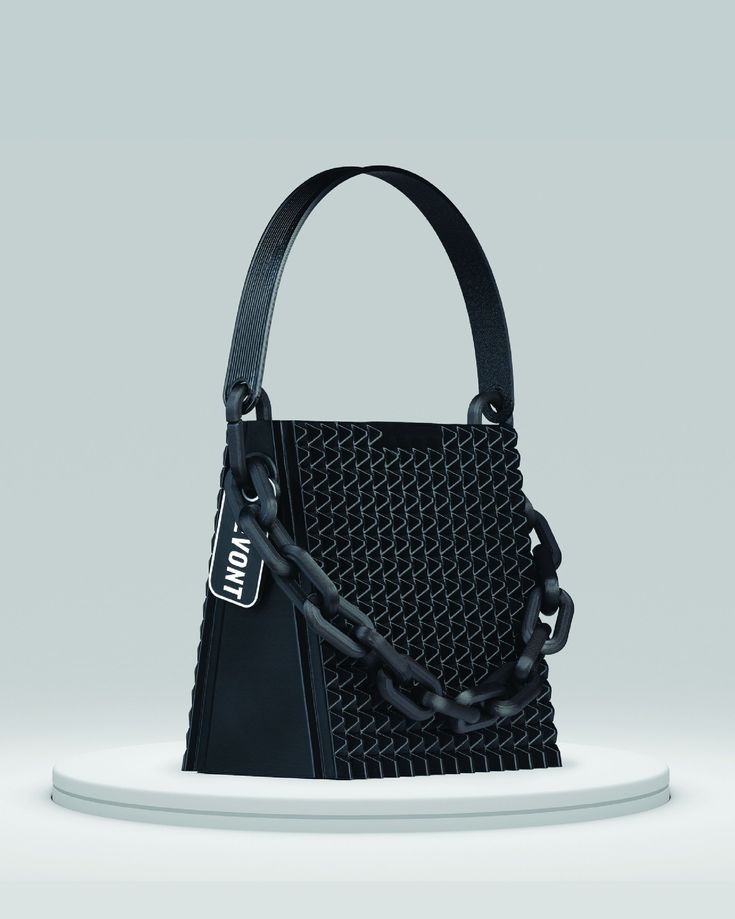 A stylish, structured handbag made from upcycled or innovative waste materials, set against a minimalist industrial backdrop, symbolising circularity, stack luxury.

