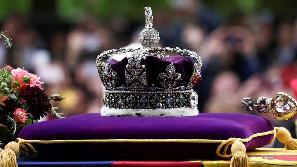 A picture showing a crown made with a purple fabric used in the queen's burial.
