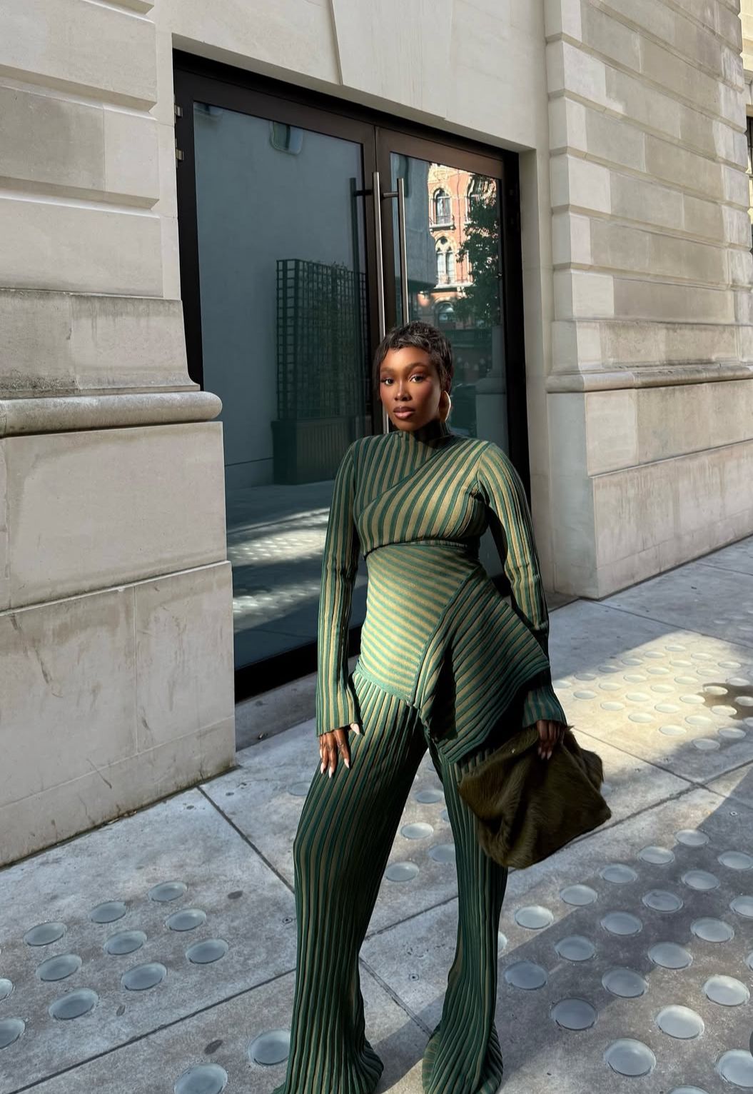 The image features a professional woman in a sleek knit set.