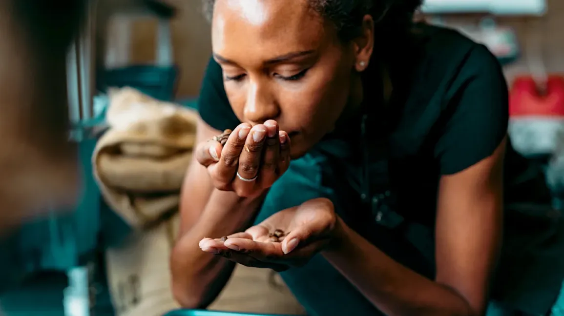A picture showing a lady trying to get the smell of a product.
