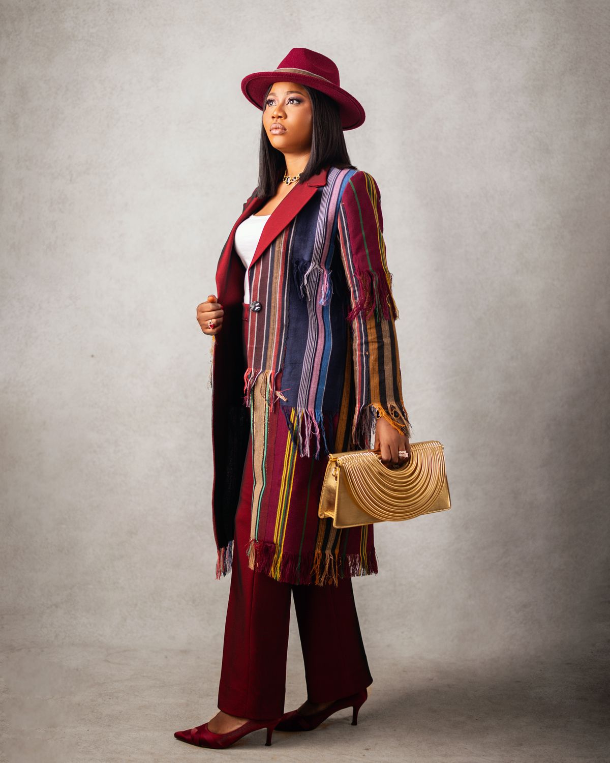 An inclusive woman in a high-end, hand-loomed Aso Oke blazer in Lagos, representing the 2026 influence of Yoruba design.