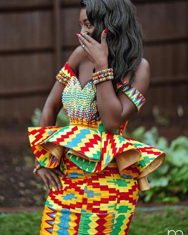 A picture of a woman wearing a gown, incorporating Kente patterns into streetwear, blending tradition and modern fashion.