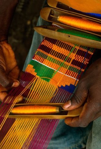 A picture of a royal Asante Kente cloth, showing gold, black, and red stripes representing kingship, ancestry, and sacrifice.