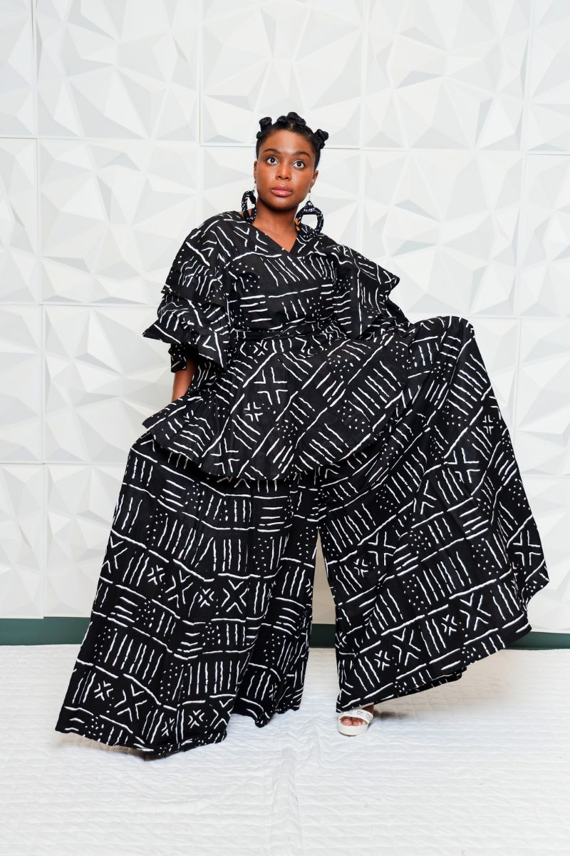 An inclusive woman in an upcycled jacket and structural trousers.