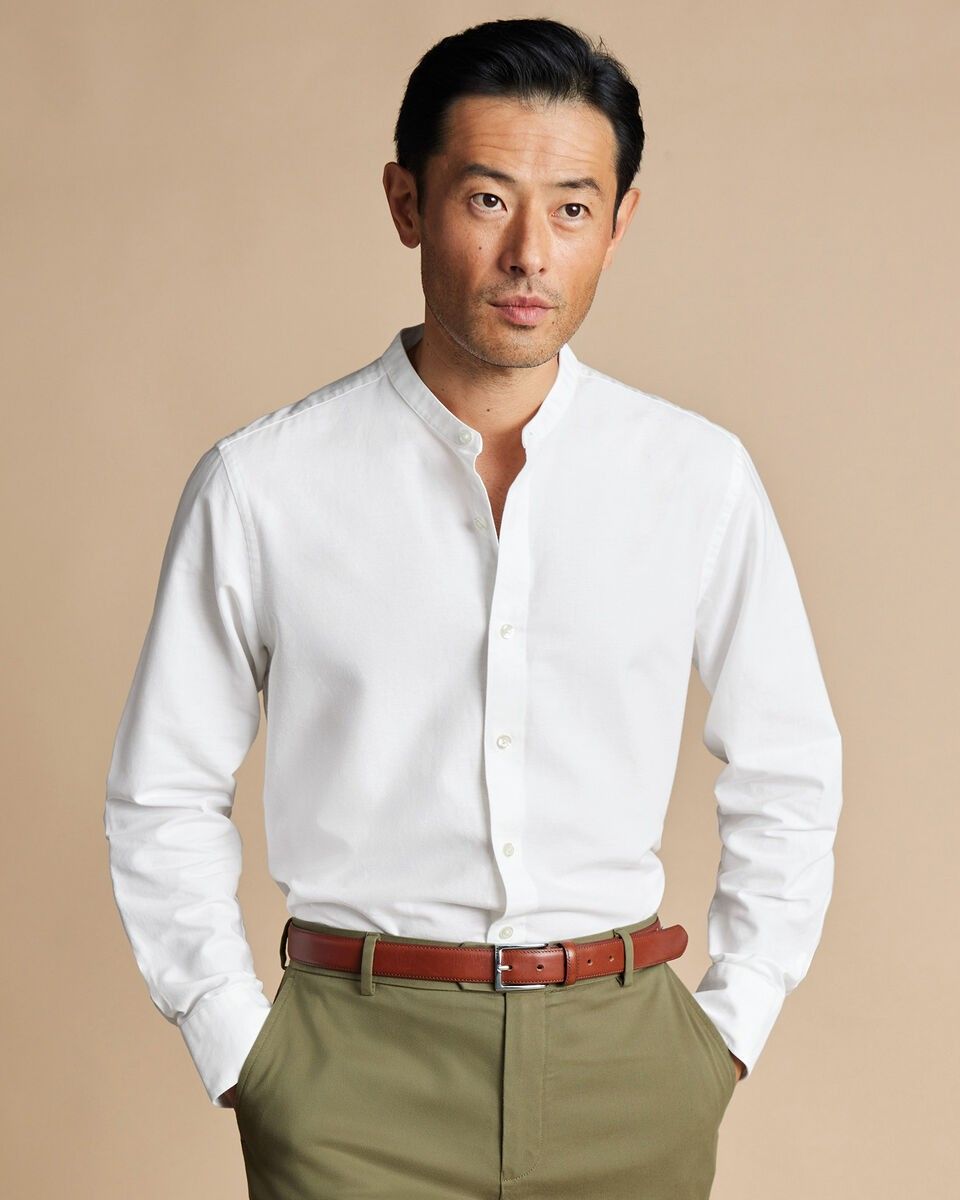 An inclusive man in a sustainable, relaxed-fit white shirt, representing the visionary fusion of comfort and modern luxury.
