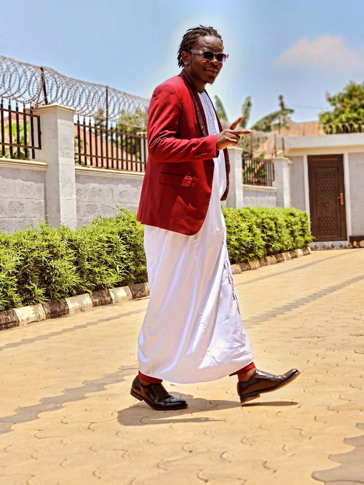 An inclusive man in a sustainable traditional Kanzu and tailored blazer, representing the visionary fusion of East African presence and modern luxury.