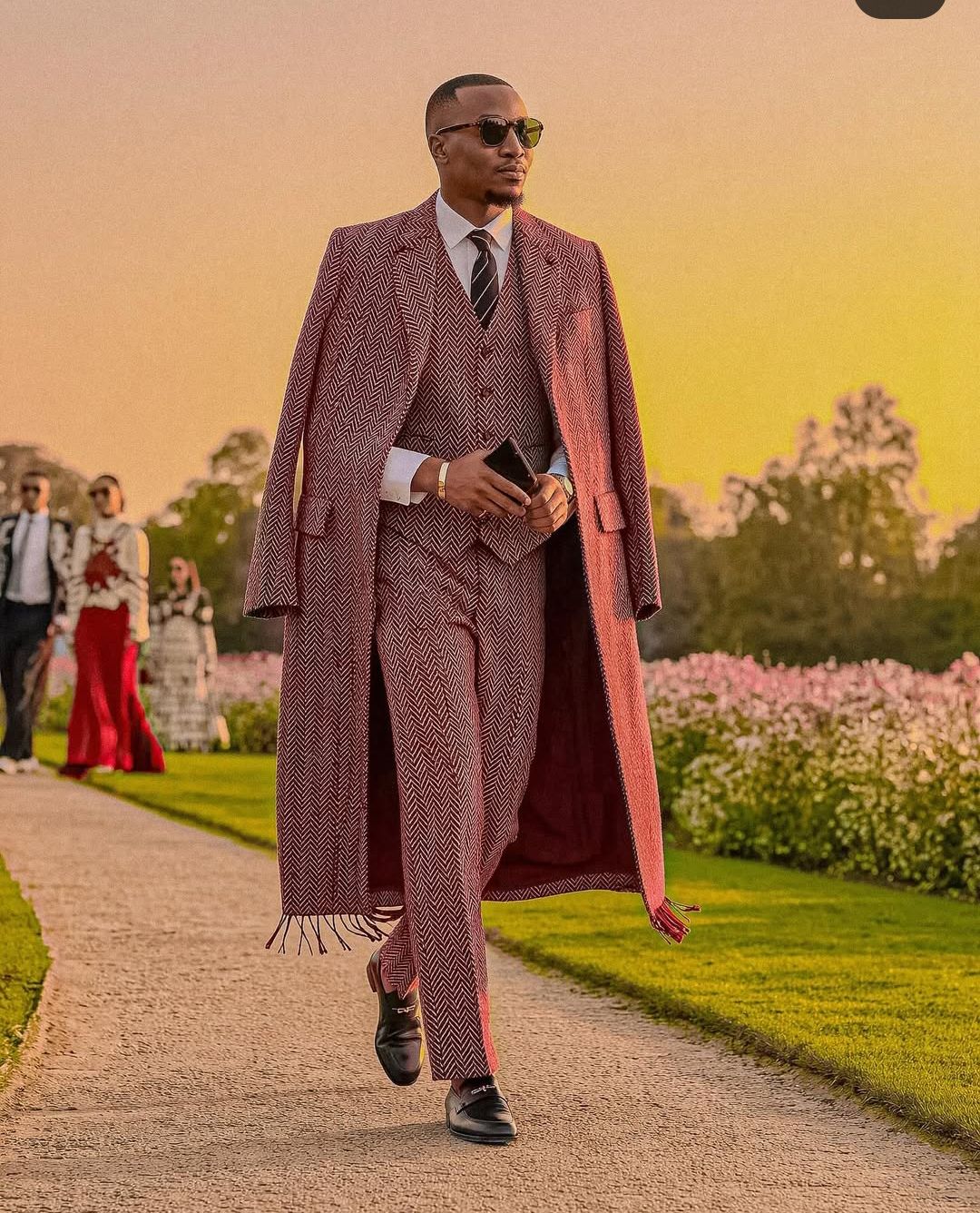 An inclusive man in sustainable luxury tailoring with a gold mechanical watch, representing the visionary fusion of modern style and timeless precision.