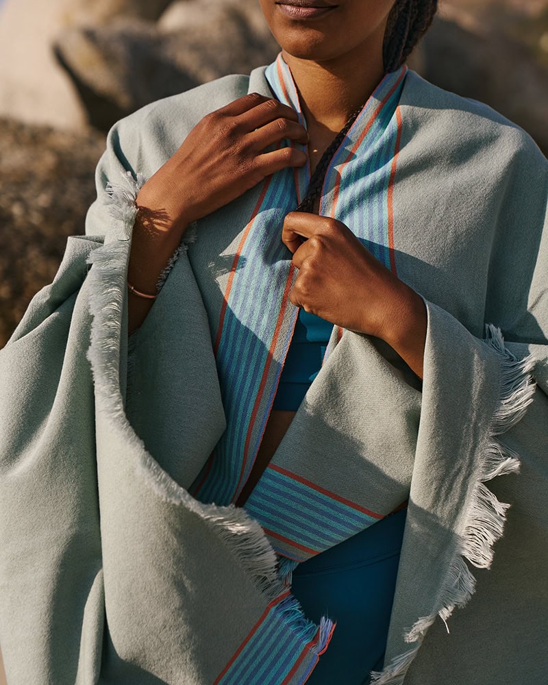 An image showing a lady using the East African Kikoi as a Shawl
