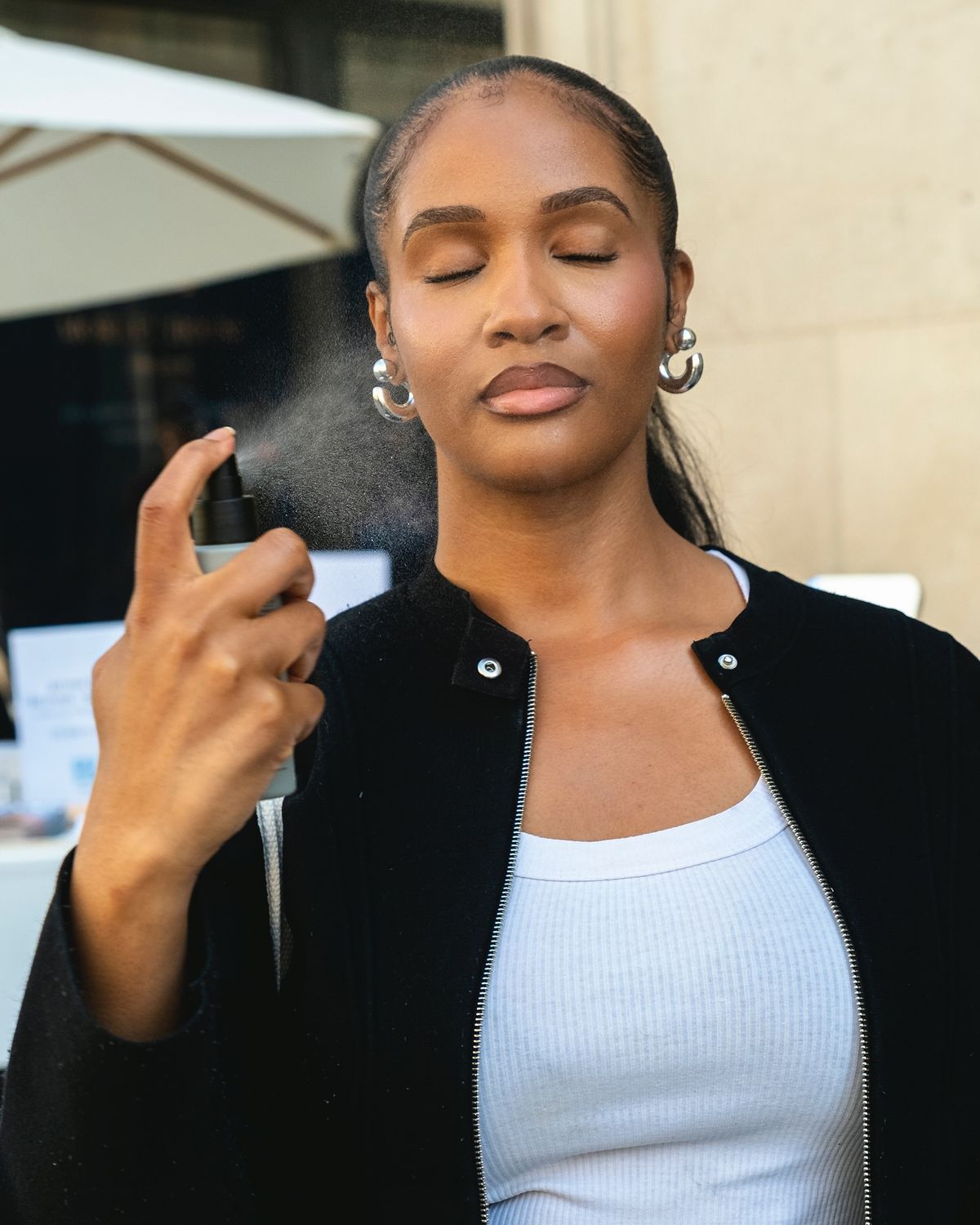  An image showing one of the steps on how to make makeup last in African heat and humidity through a setting spray
