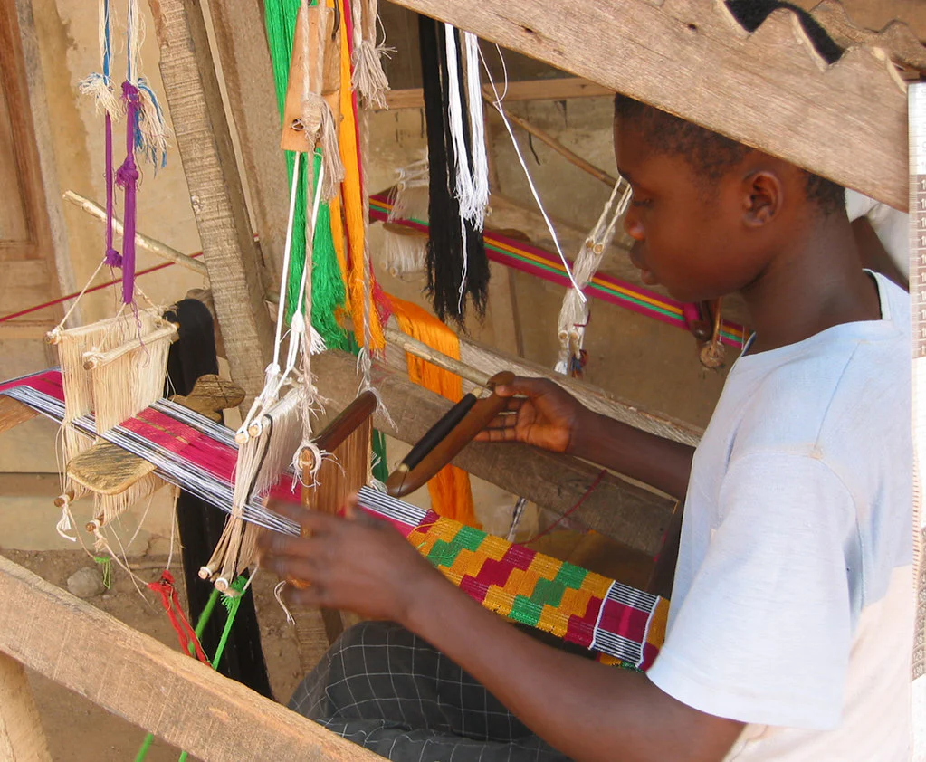An image showing a young man making the Kente cloth
