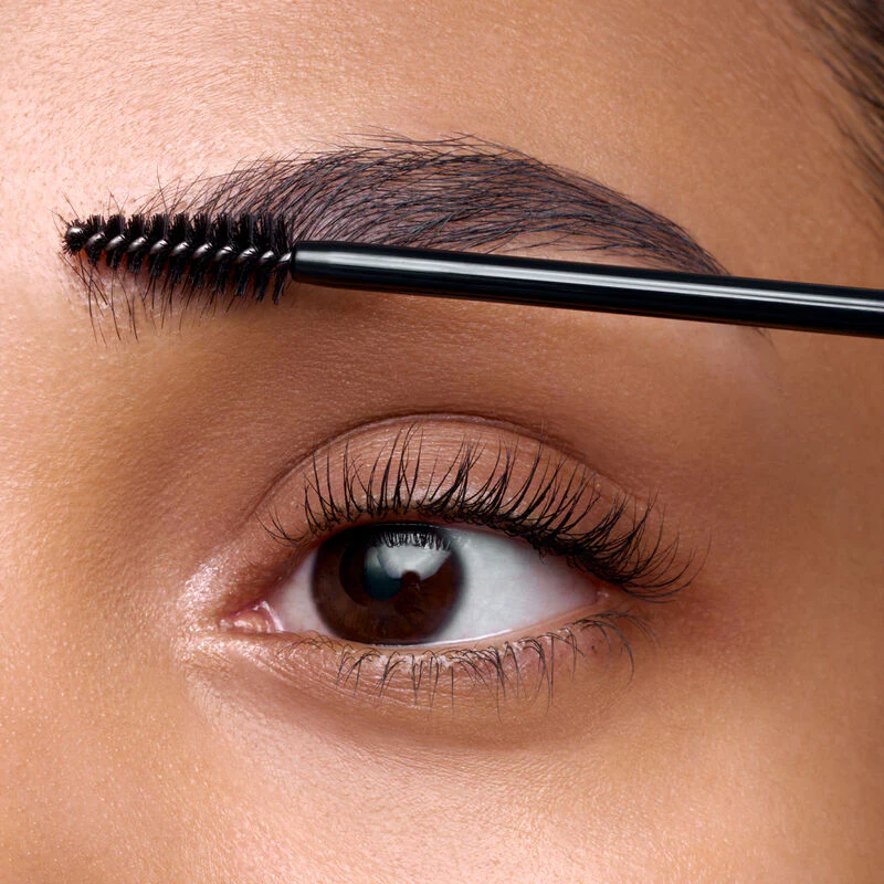 An image showing a lady grooming her eyebrow with eyebrow gel
