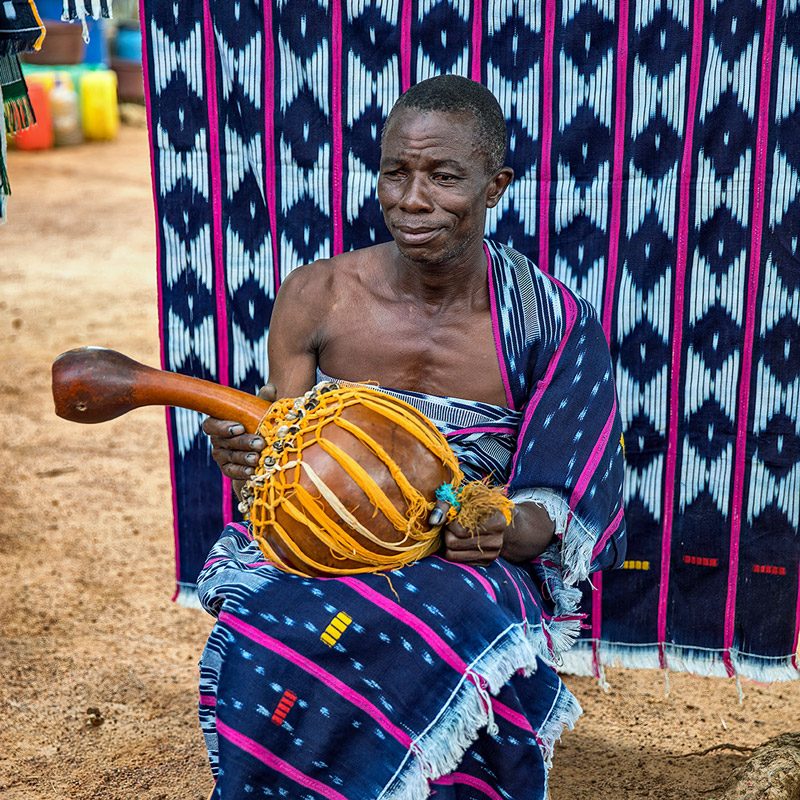 An image showing a Baoulé man sitting. One of the ethnic groups that demonstrates traditional clothing in Côte d'Ivoire