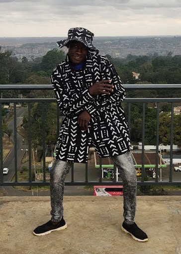 An image showing a guy wearing a shirt made with mudcloth and trousers