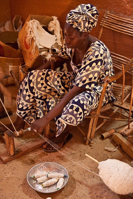 An image showing a weaver preparing a loom for Malian textile. One of the processes that affects sustainable fashion in Mali
