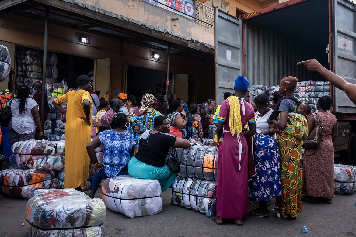 An image showing women from Kantamanto Market with clothing bales, revealing circular fashion economy.