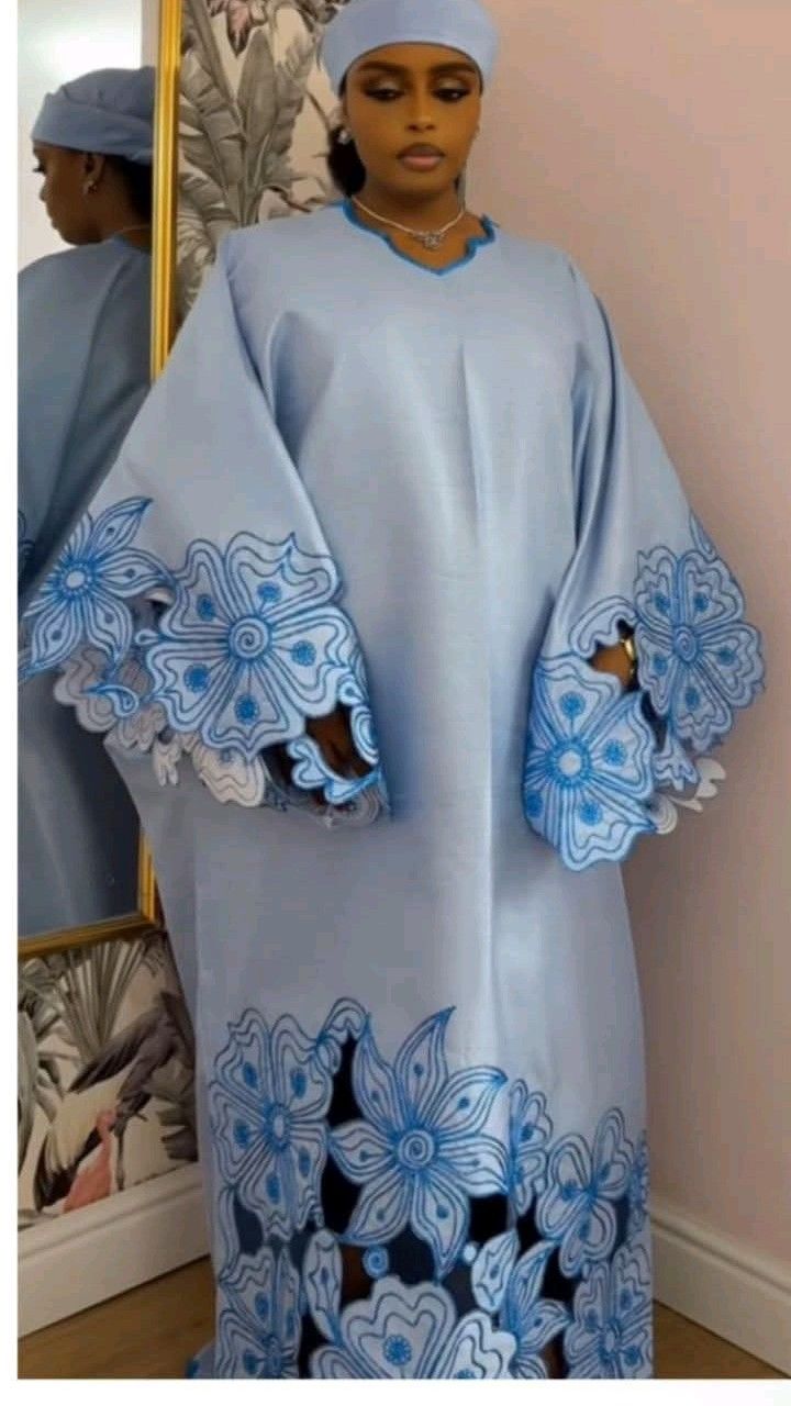 Senegalese woman wearing a contemporary embroidered boubou with sculptural sleeves designed for modern urban fashion.