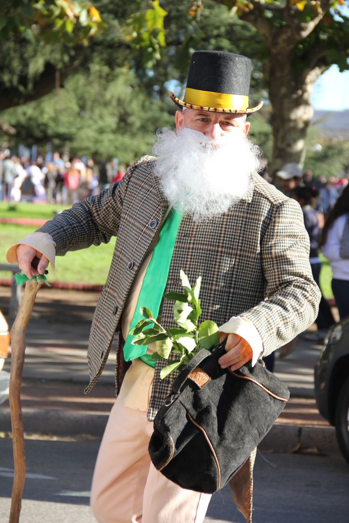 Gramillero Candombe character in frock coat, top hat, cane, white beard, and herb suitcase. 