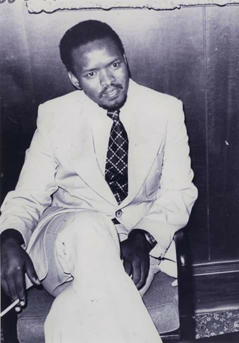 Steve Biko portrait surrounded by Black Consciousness era Afro hairstyles, beads, and African-inspired dress.