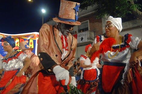 Afro-Uruguayan Candombe drummers and dancers moving through Montevideo during a Llamada procession.