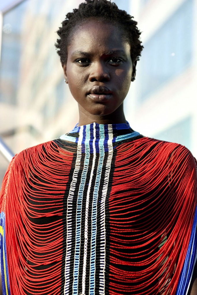 A South Sudanese woman wearing a red Dinka-inspired beaded corset