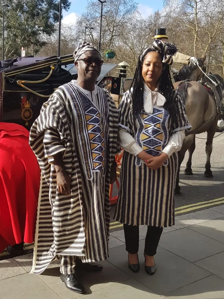 A couple wearing black-and-white striped country cloth garments with geometric detailing.