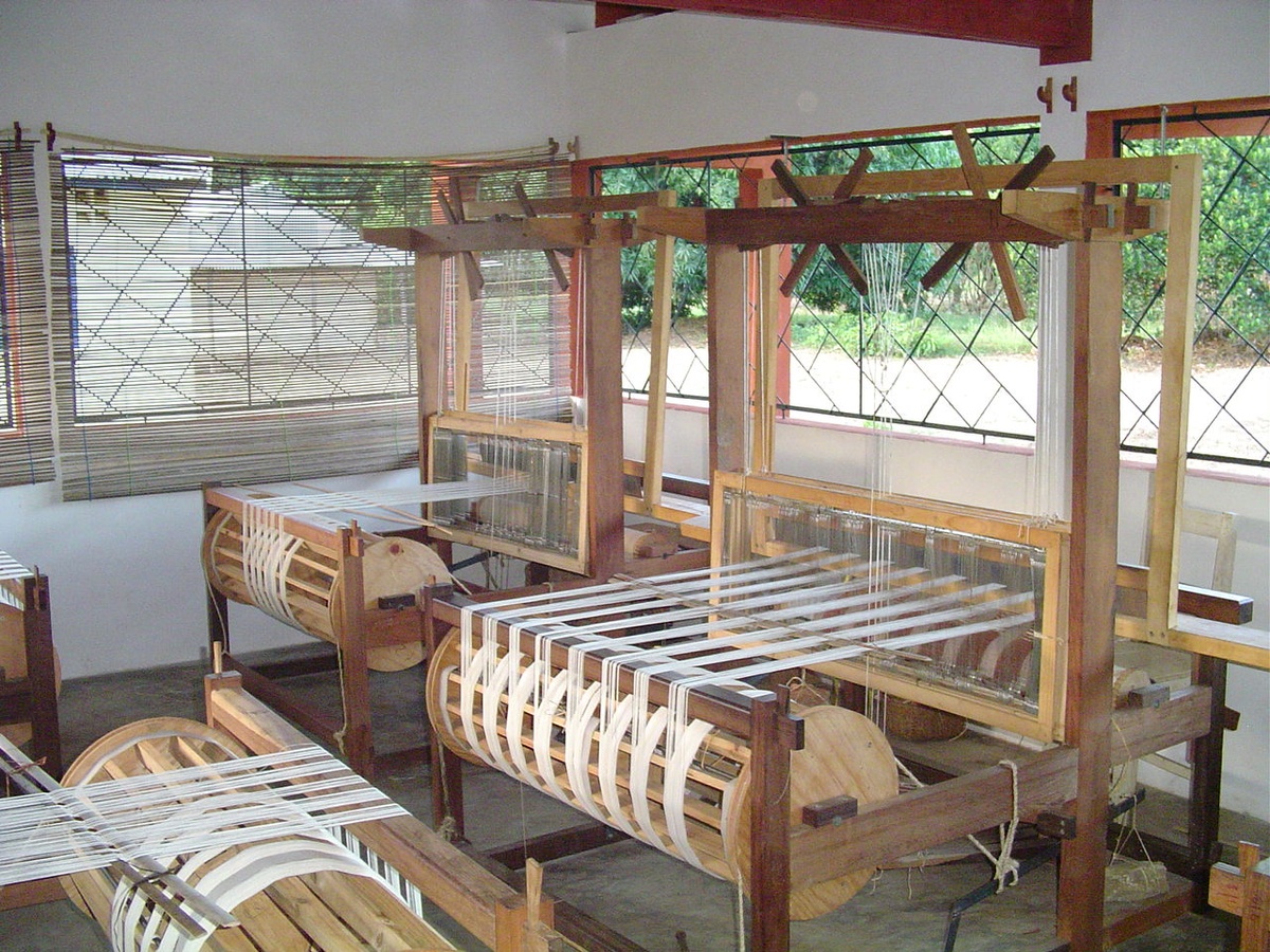 Ivorian handloom weaver preparing cotton warp threads for a domestic textile production season.