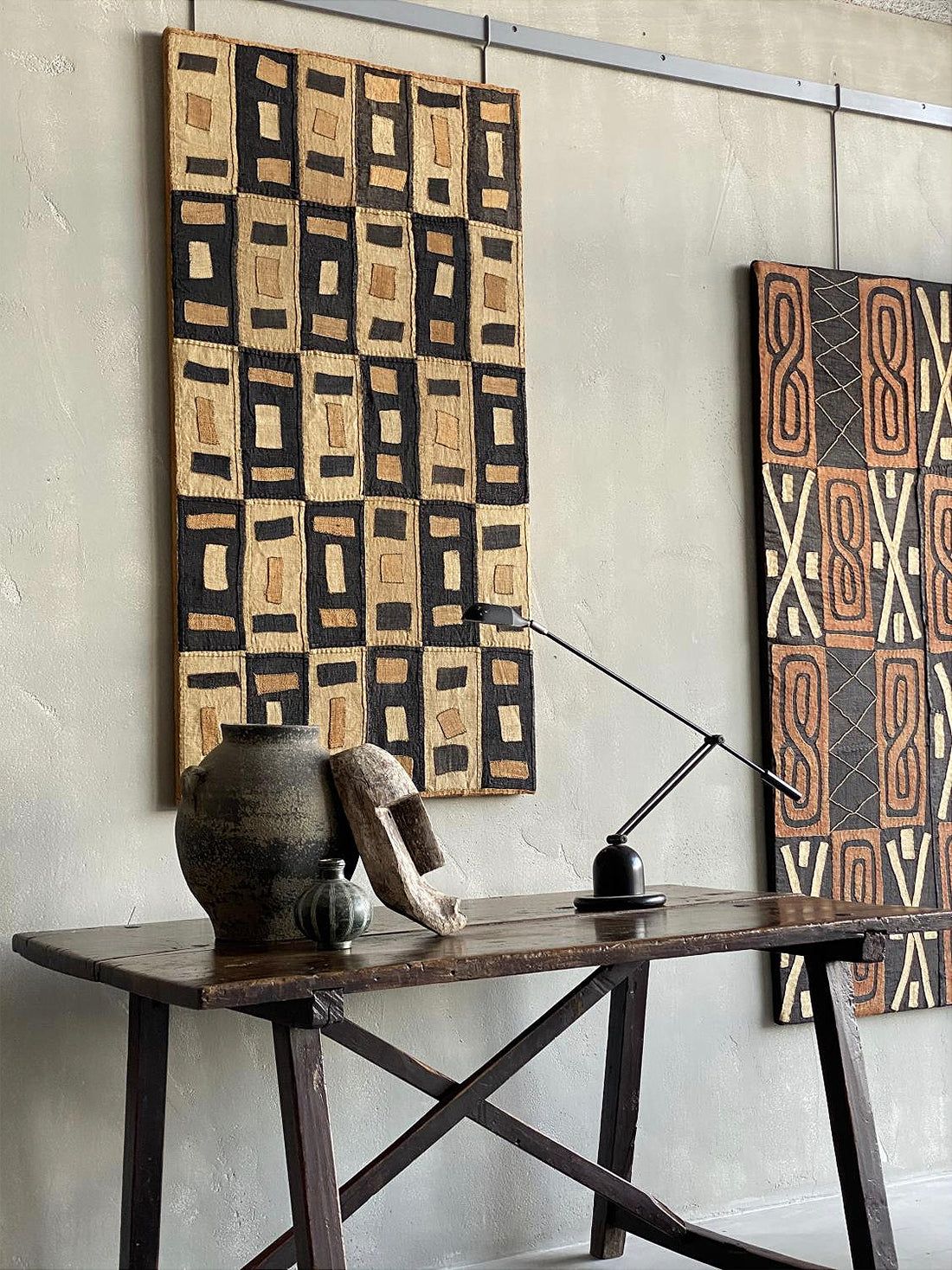 Authentic Kuba raffia cloth displayed as geometric wall art in a contemporary interior.