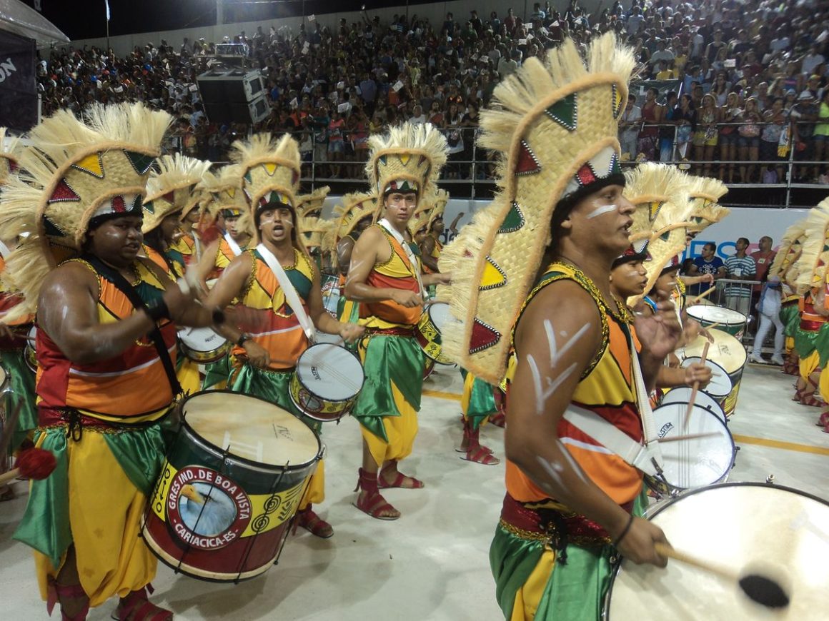 Candombe drummers in coordinated shirts, vests, scarves, and hats playing drums during Montevideo Llamada.