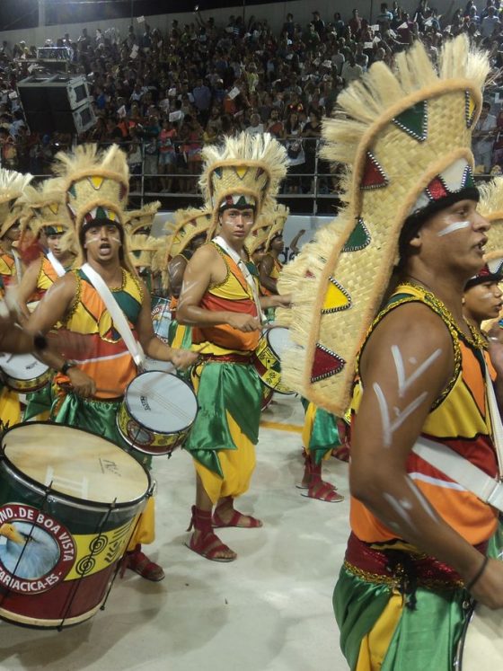 Candombe drummers in coordinated shirts, vests, scarves, and hats playing drums during Montevideo Llamada.