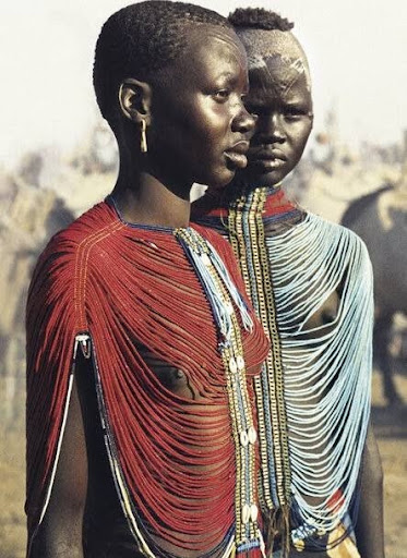 Two South Sudanese woman wearing a red and blue Dinka beaded corset.